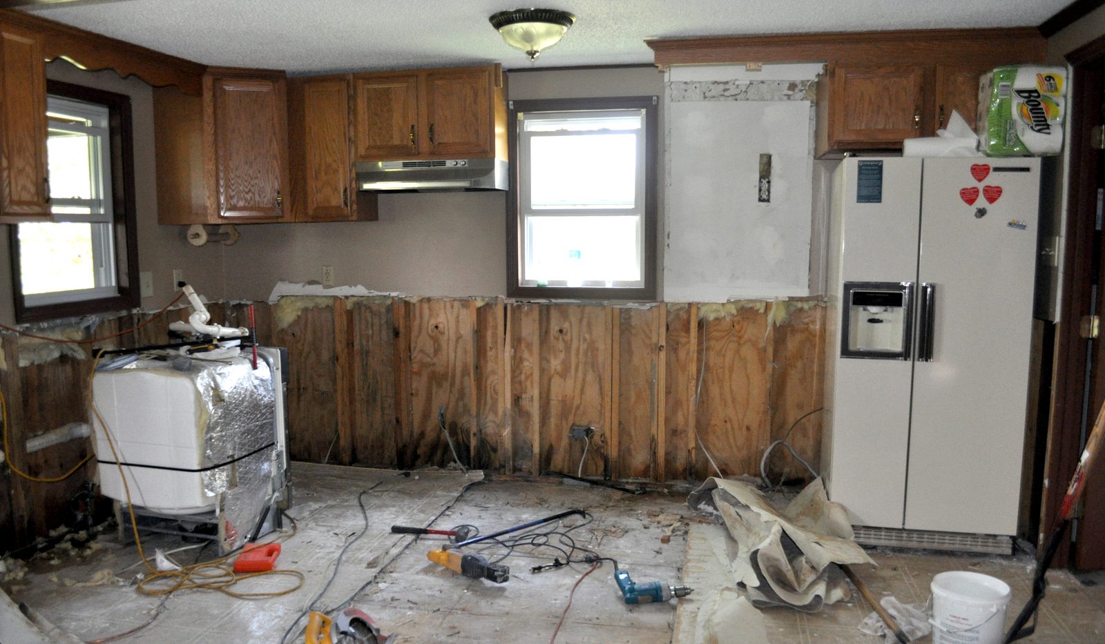 Kitchen after mitigation with the wet drywall cut out to the studs and the cabinets kept