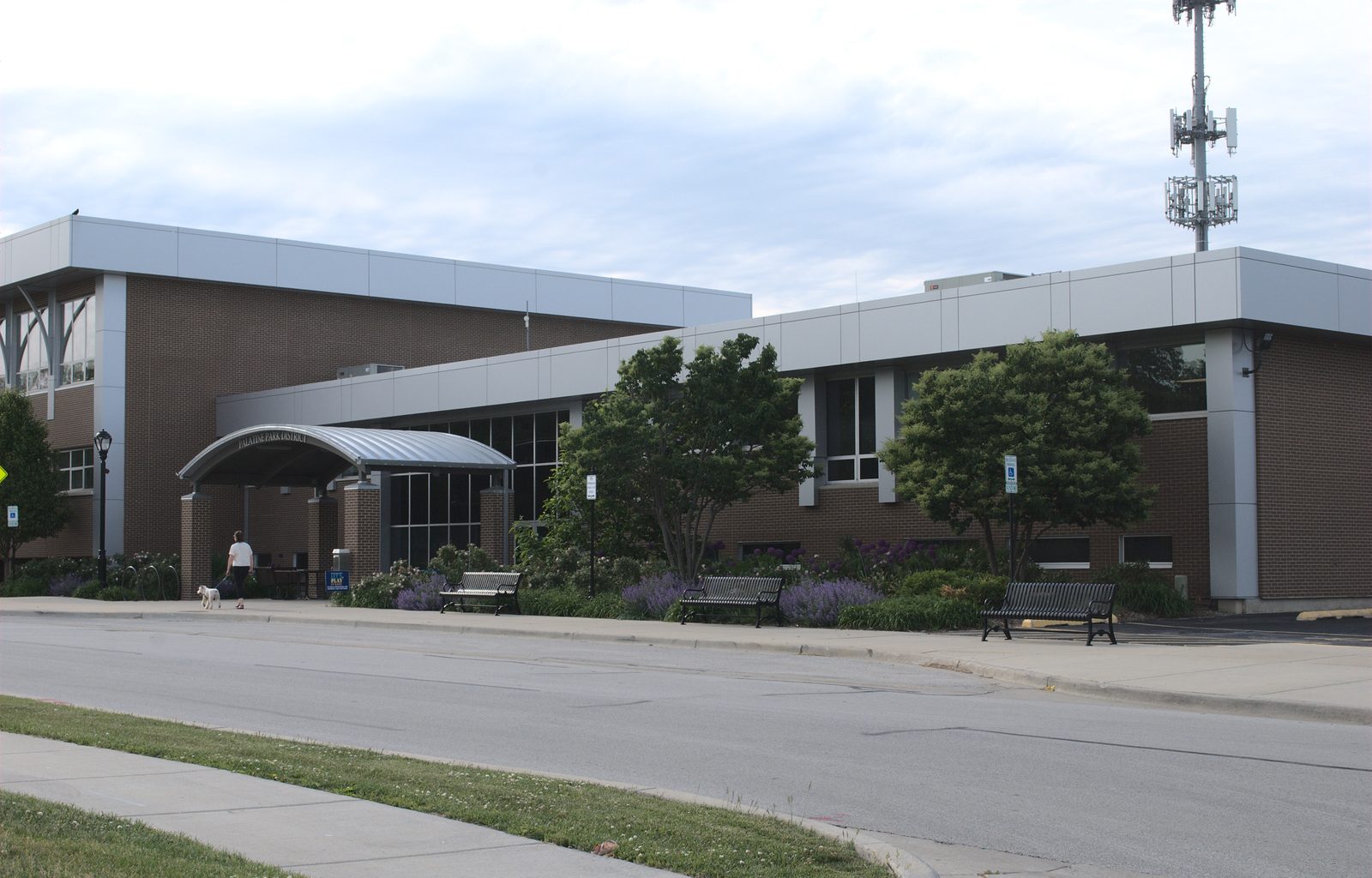 Brick park district community center with a curved entry canopy and benches out front